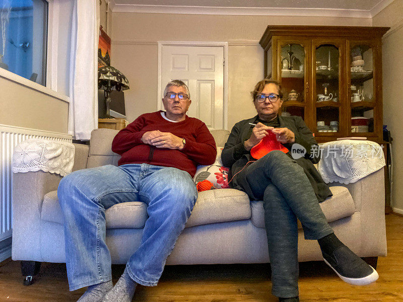 Senior mixed ethnicity couple watching TV on sofa